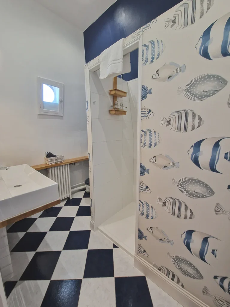 Salle de bains privative avec grand lavabo, douche à l'italienne spacieuse et WC intégrés.